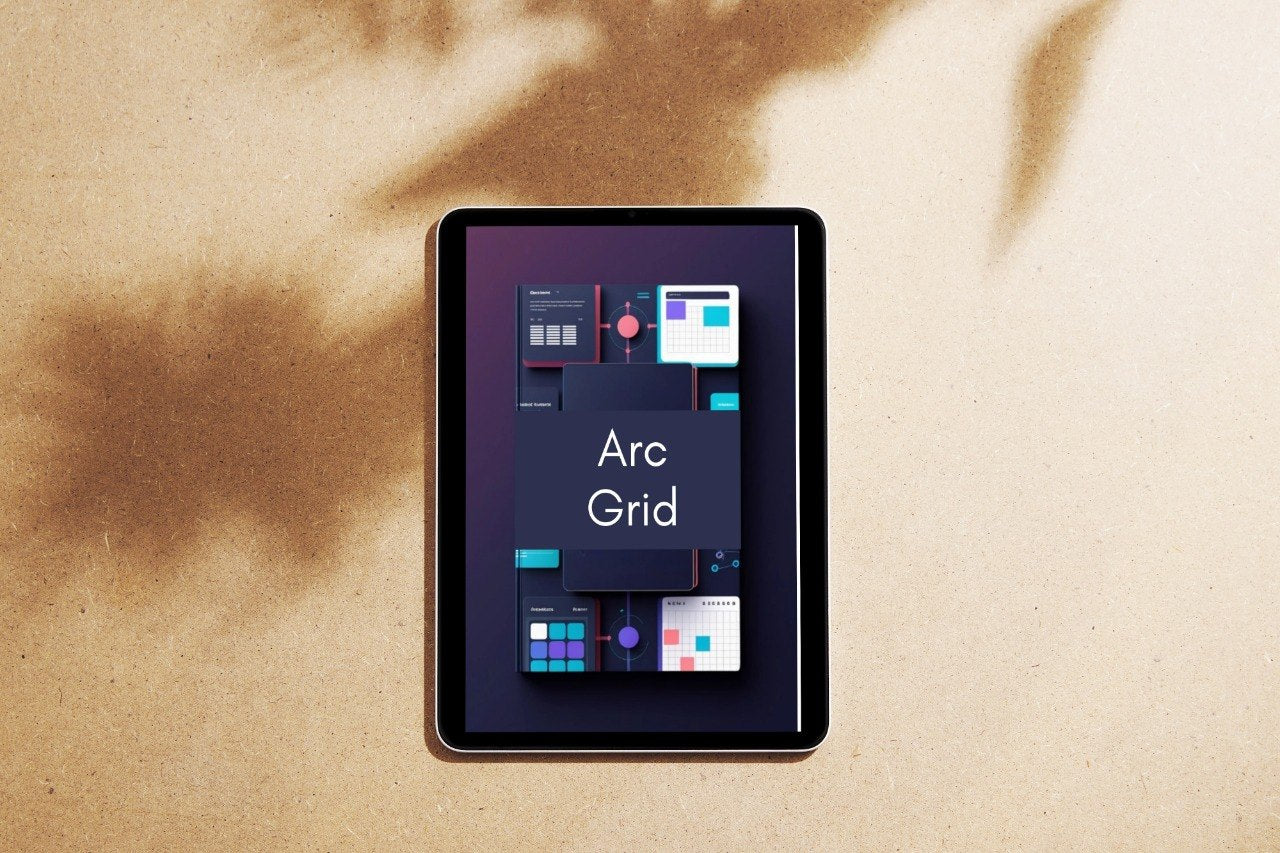A tablet device lying on a textured beige surface with soft brown shadows cast across it. The screen displays a dark interface with the text 'Arc Grid' and several colorful app-style tiles.